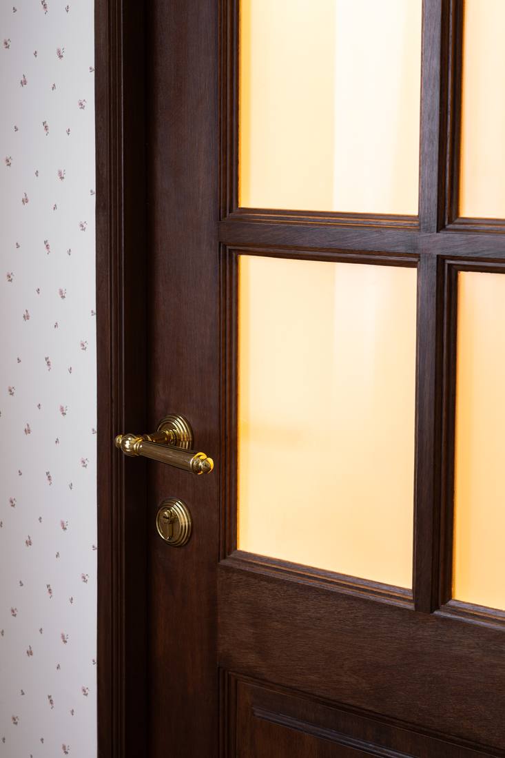 A dark timber door with brass hardware