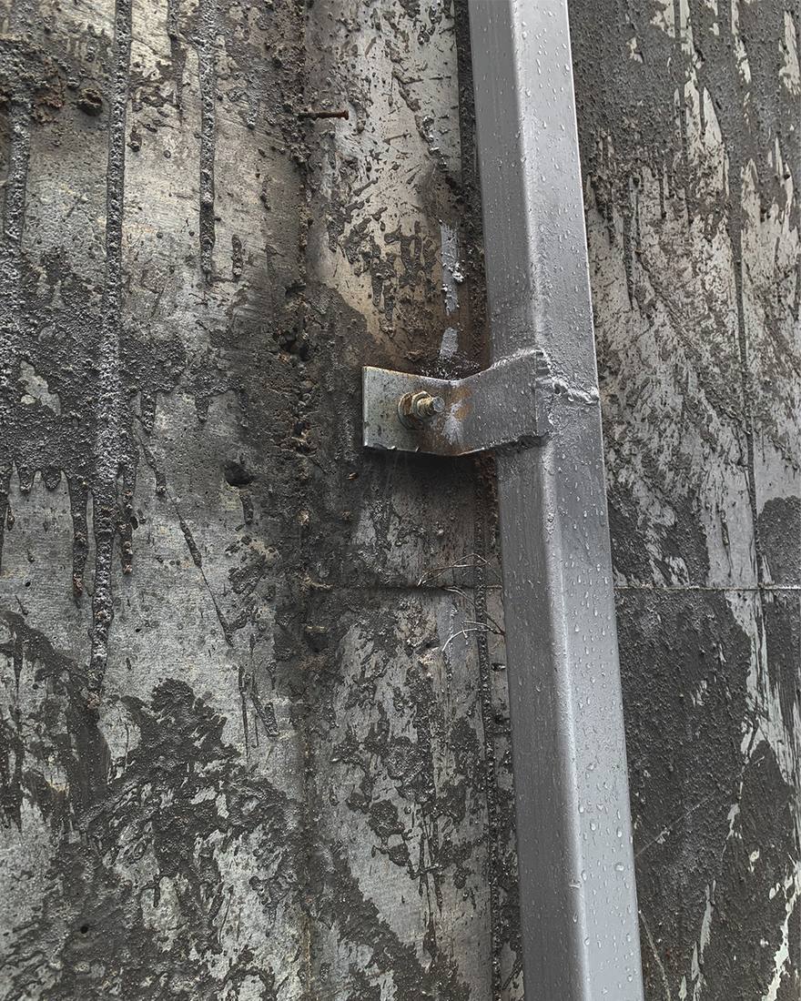 A steel bracket fixed into weathered stone on site